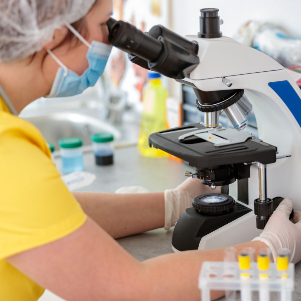 Lab Technician Looking in Microscope